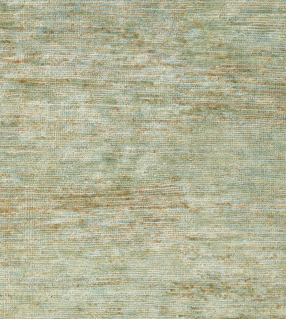 Close-up of a green-teal and beige woven rug with a soft, mottled texture.