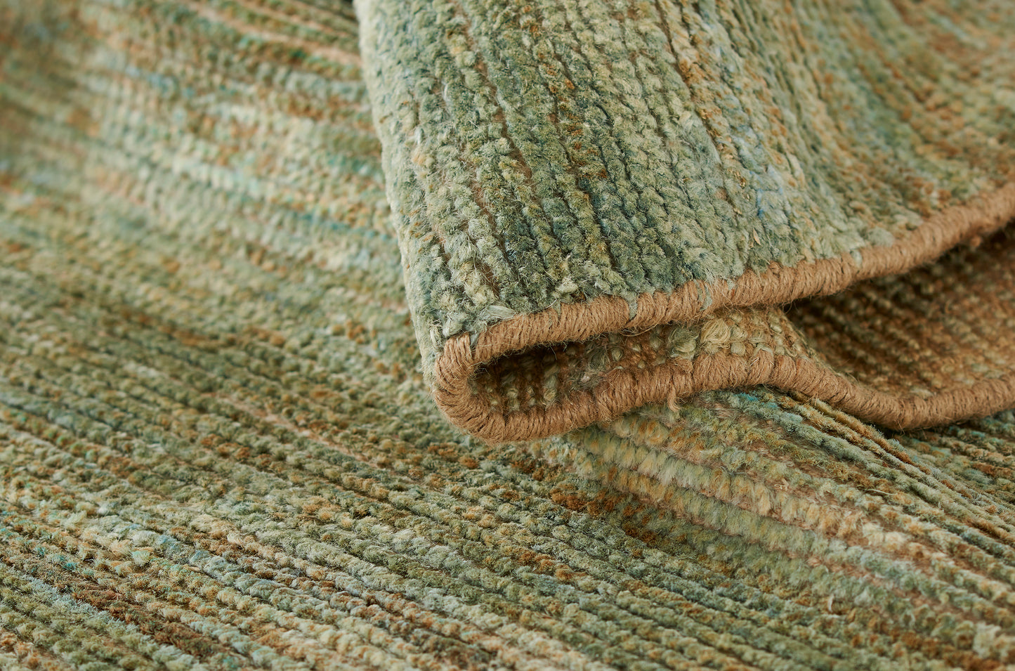 Green textured loop-pile rug with tan border; sage-brown tones add cozy woven style.