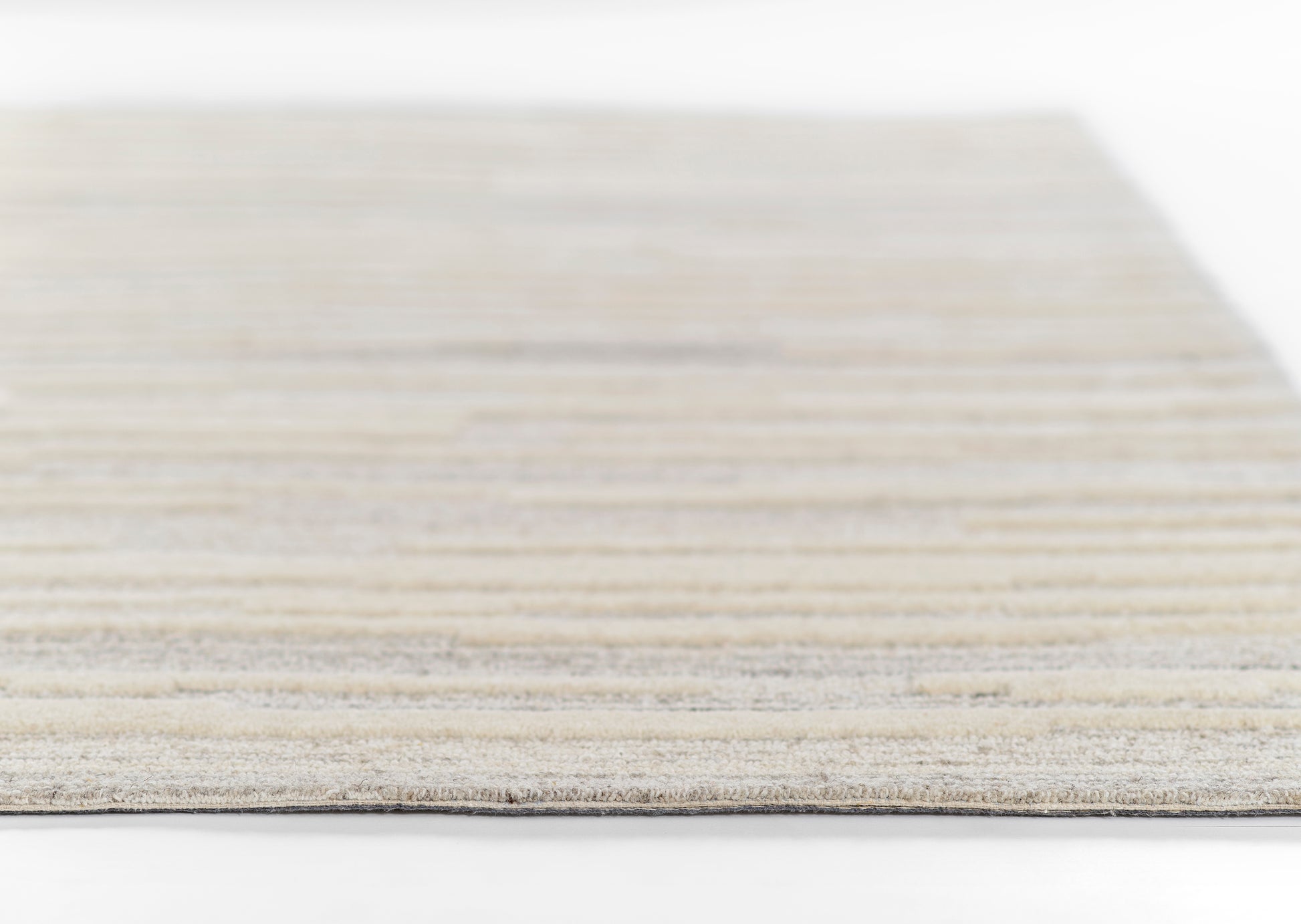 Gray and beige striped woven rug with soft texture and low-pile weave, rectangular rug.