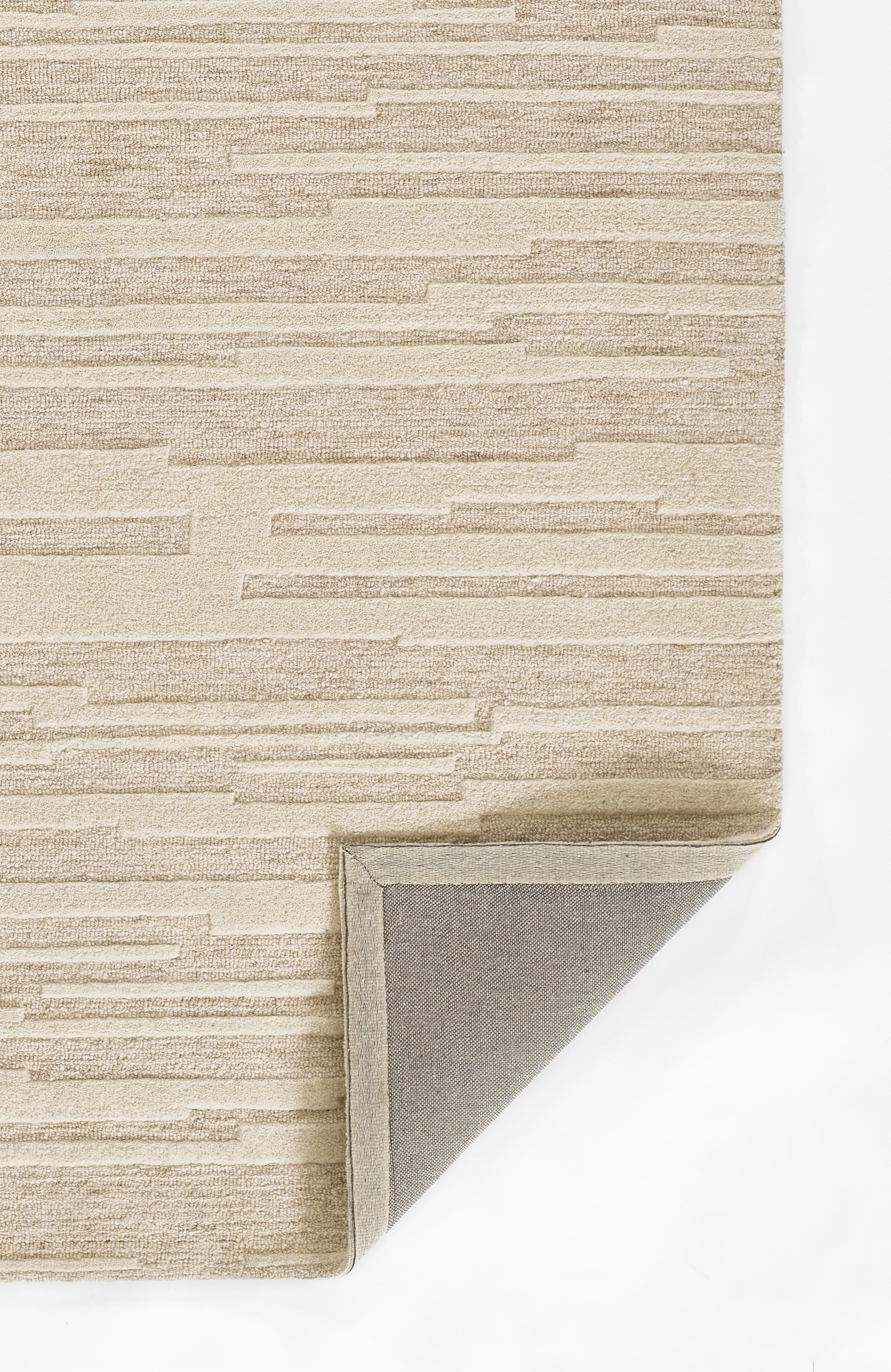 Taupe textured area rug with horizontal stacked pattern; rectangular with folded corner showing backing.