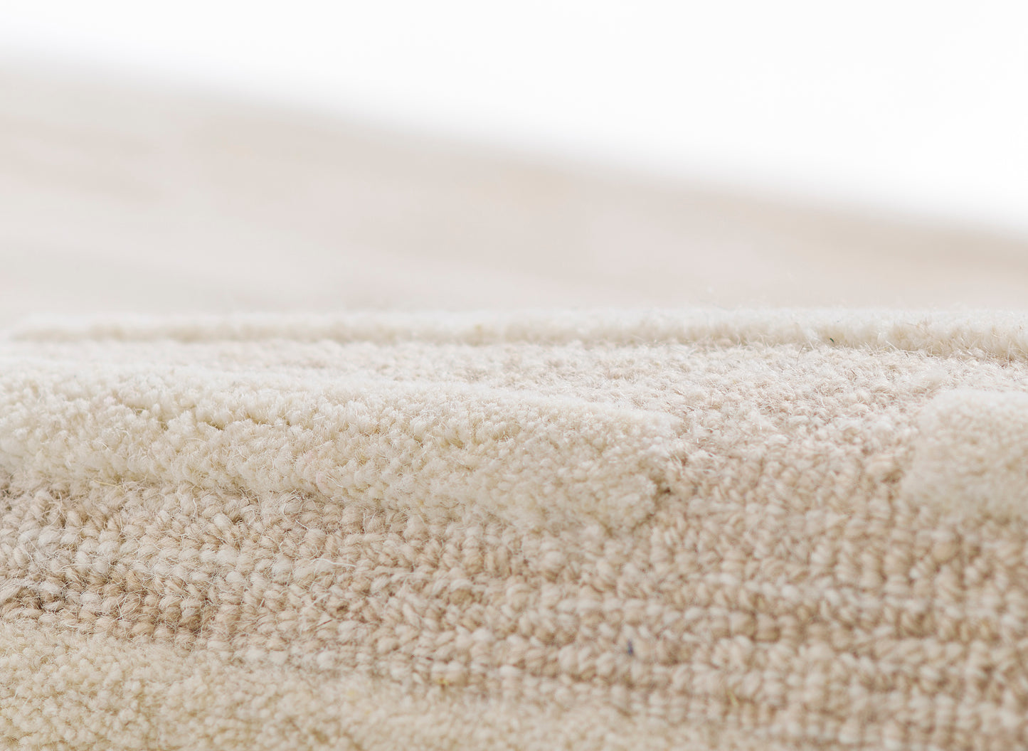 Beige textured runner rug with plush loop fibers; close-up, soft neutral decor.