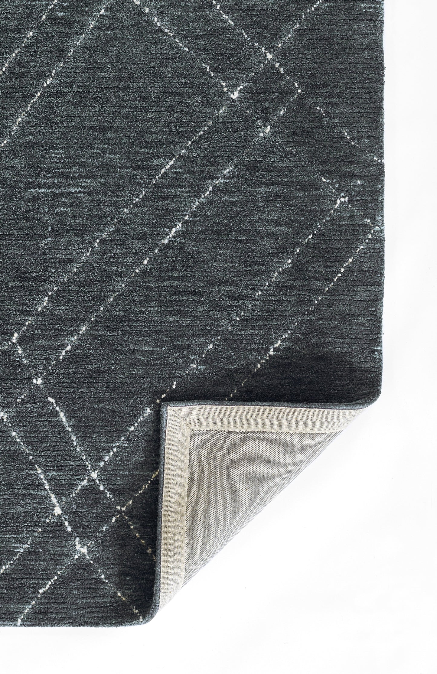 Navy blue rug with a white diagonal grid pattern, textured weave, folded corner reveals light gray backing.
