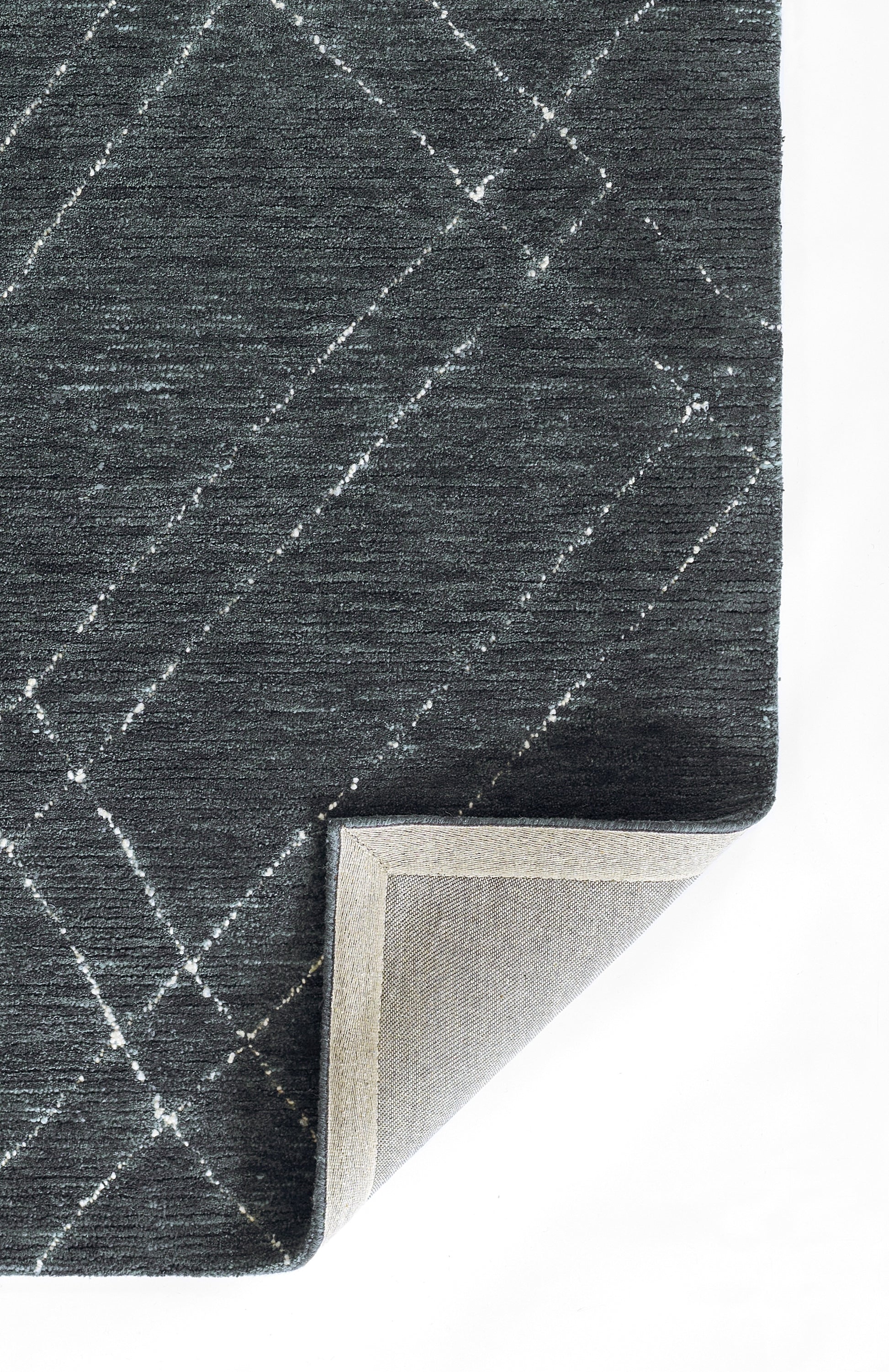 Navy blue rug with a white diagonal grid pattern, textured weave, folded corner reveals light gray backing.