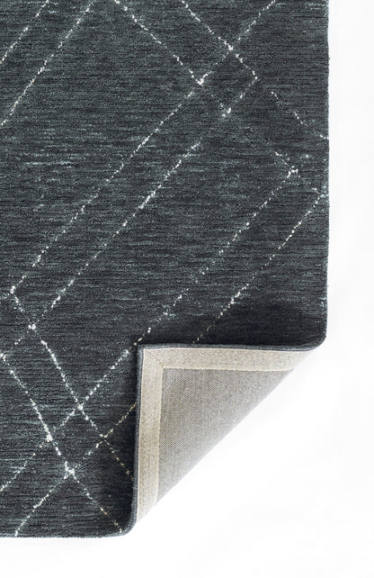 Dark blue-gray rug with a white diagonal lattice pattern; corner folded to reveal light beige backing.