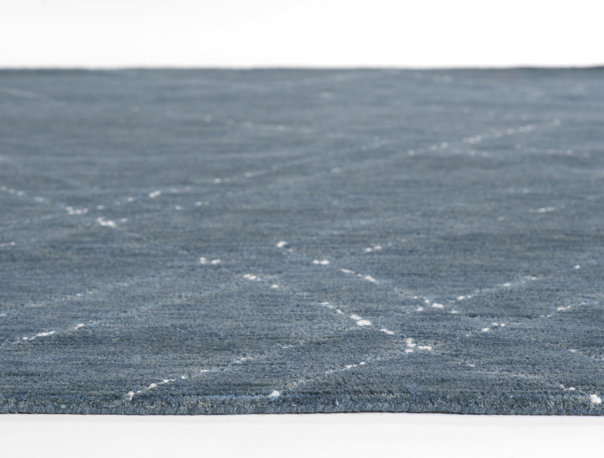 Blue textured area rug with a subtle white dashed lattice pattern; low-pile, rectangular 5' x 8' rug, modern casual style.