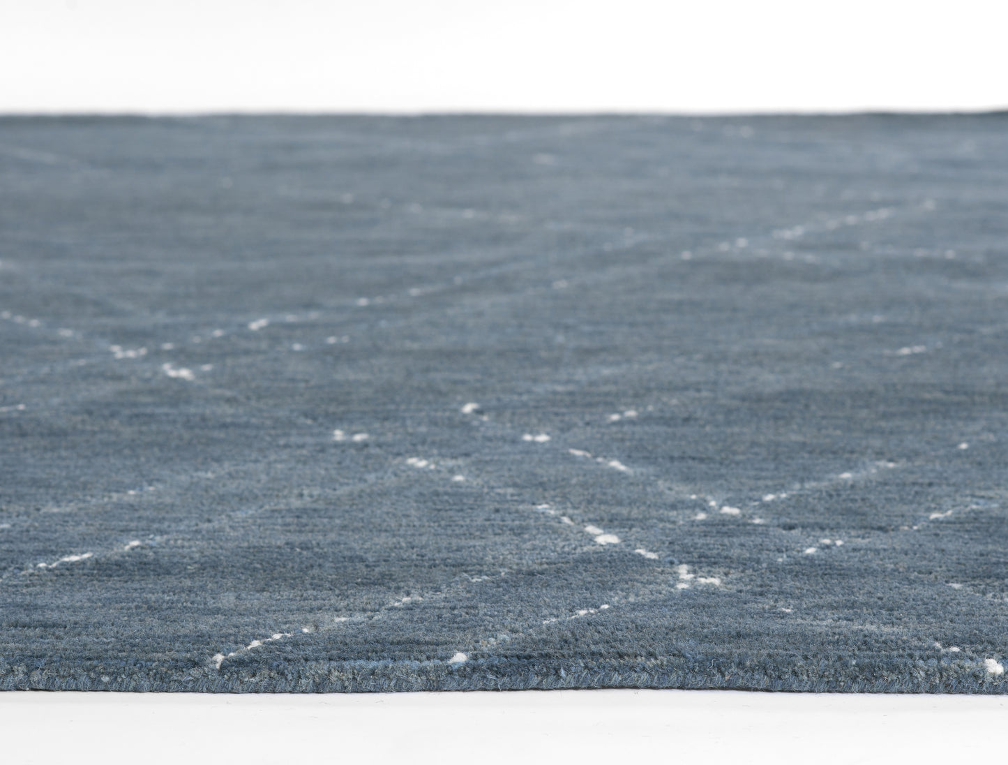Blue textured rectangular rug with subtle white dashed lattice pattern; plush, modern decor for living spaces.