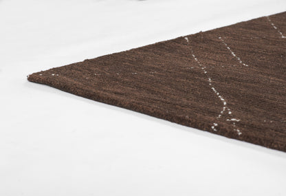 Brown textured rug corner with white geometric diamond pattern.
