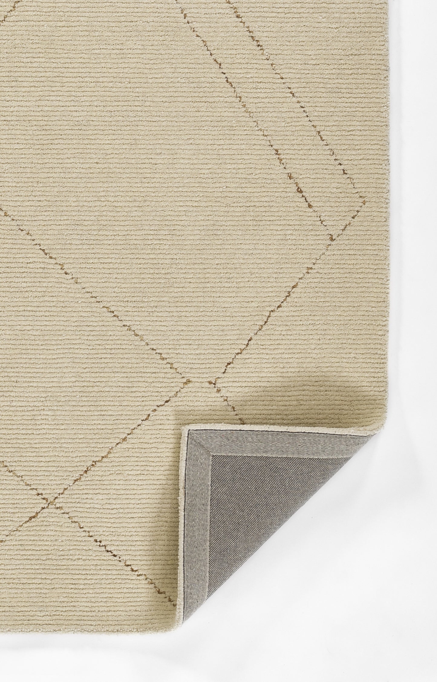 Beige textured rug with stitched diamond pattern; folded corner showing light gray backing.