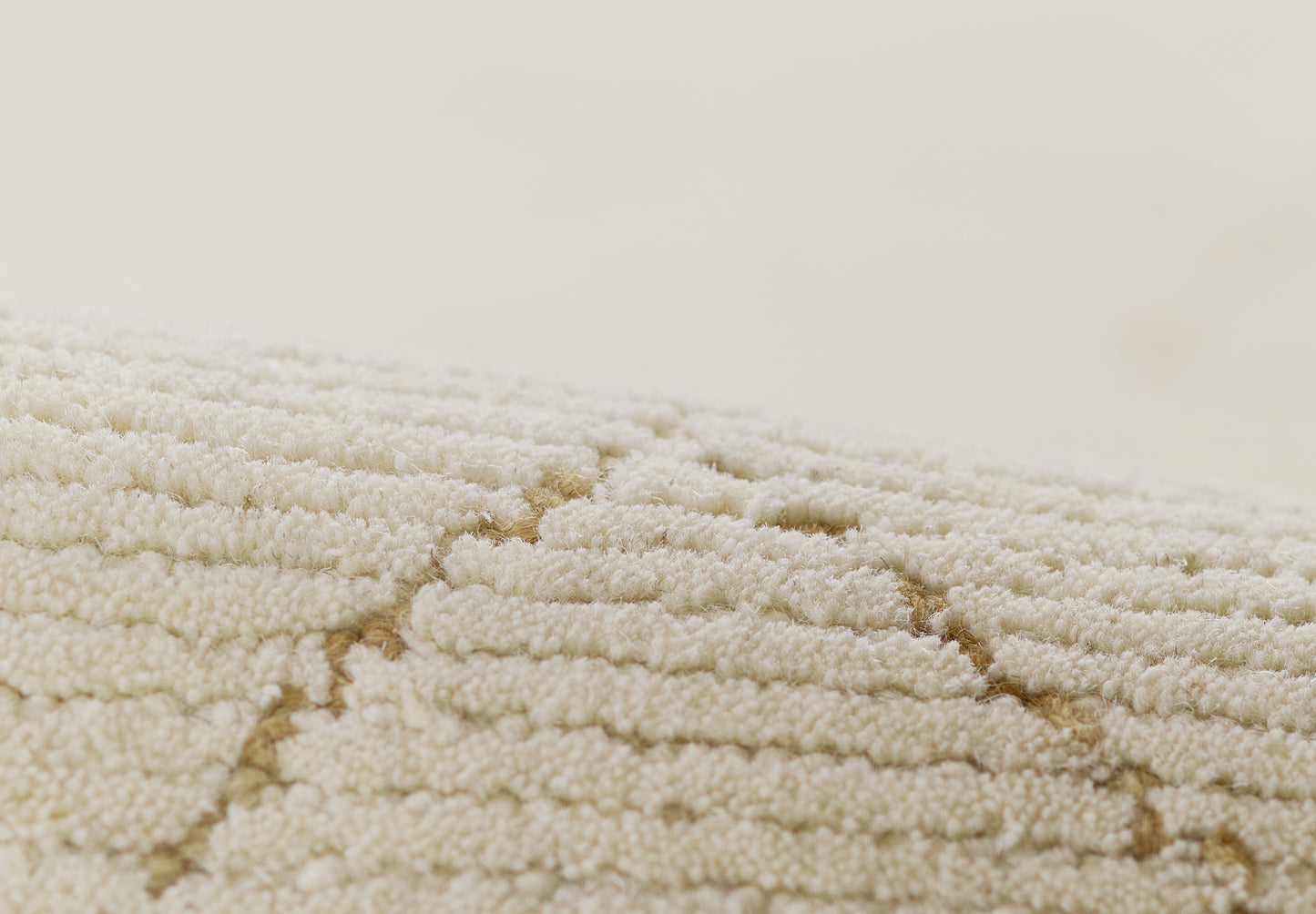 Cream ivory shag rug close-up with textured loop pile & geometric diamond pattern.