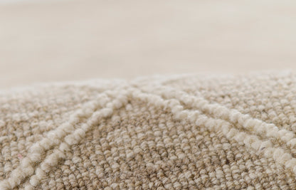 Natural beige looped rug texture with soft, tight fibers and subtle woven look.