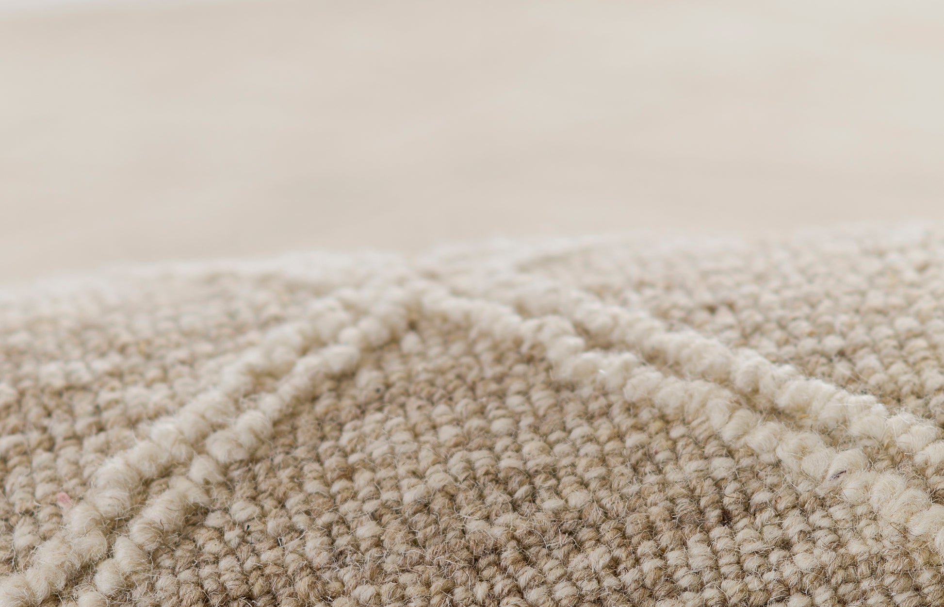 Natural beige loop-pile rug close-up with a soft, textured surface.
