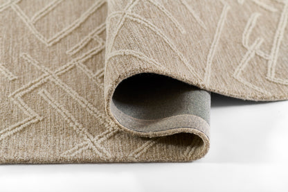 Beige textured area rug with a geometric raised pattern, curled edge exposing the soft gray underside.