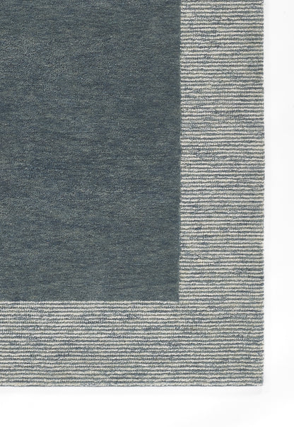 Rectangular navy rug with a dark central panel and a light gray striped border, woven texture.