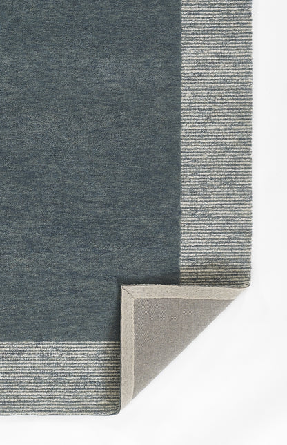 Dark navy area rug with a pale striped border; corner folded to reveal light beige back.