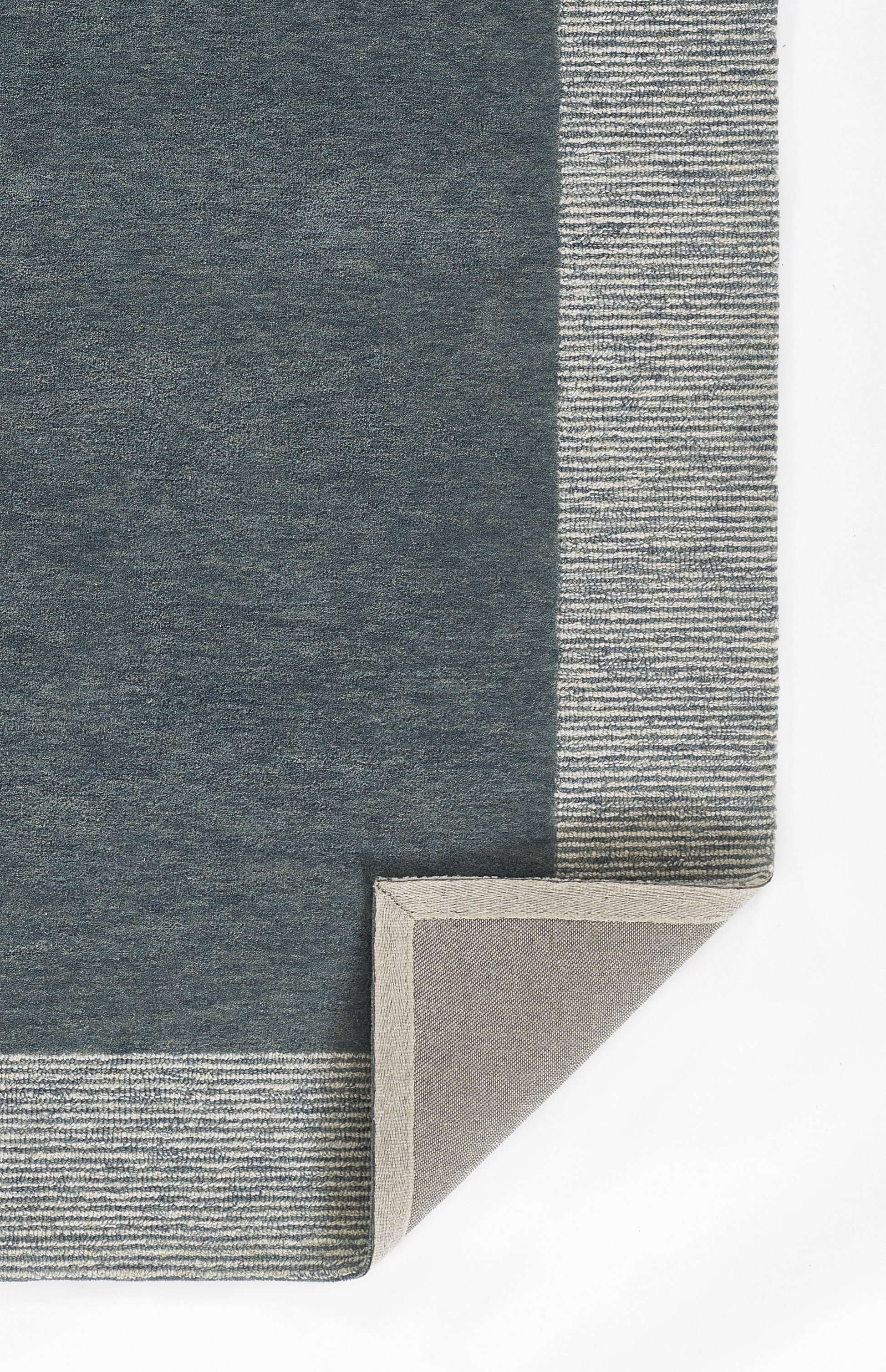 Dark blue-gray runner rug with a light striped border; corner folded to show beige backing.