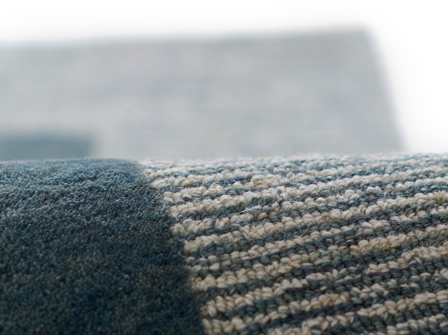 Close-up of blue & beige striped woven rug edge, textured loop pile.