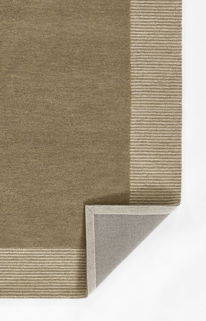 Taupe area rug with light tan ribbed border; corner folded to reveal gray backing.