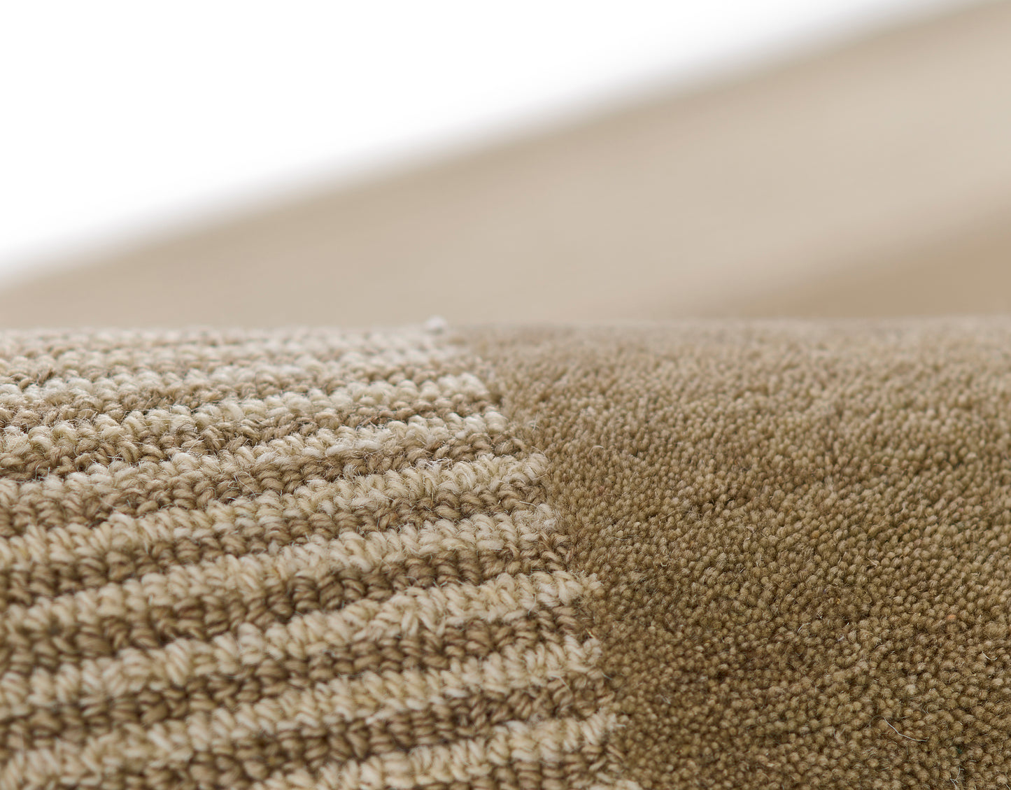 Close-up of beige loop-pile rug with striped textured weave and solid tan section.