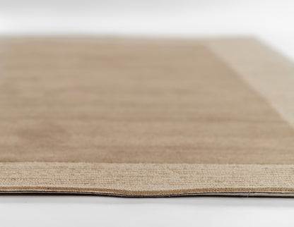 Close-up of a beige rug showing soft pile and woven texture; rectangular 9' x 12' rug.