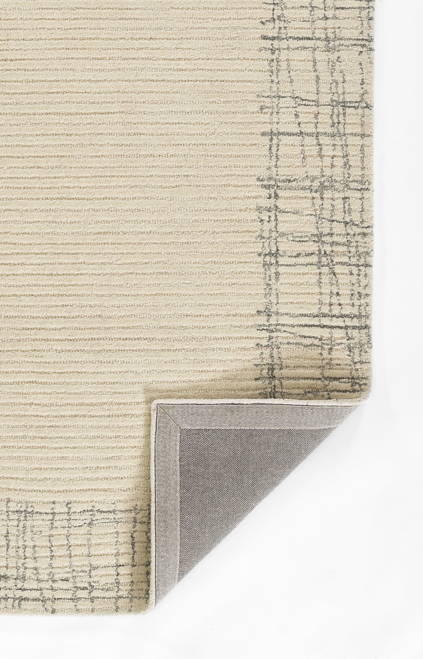 Beige textured rug with subtle stripes and gray plaid border; folded corner reveals soft backing.