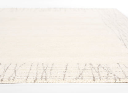 Rectangular cream flat-weave rug with a light taupe border motif; soft, neutral home decor.