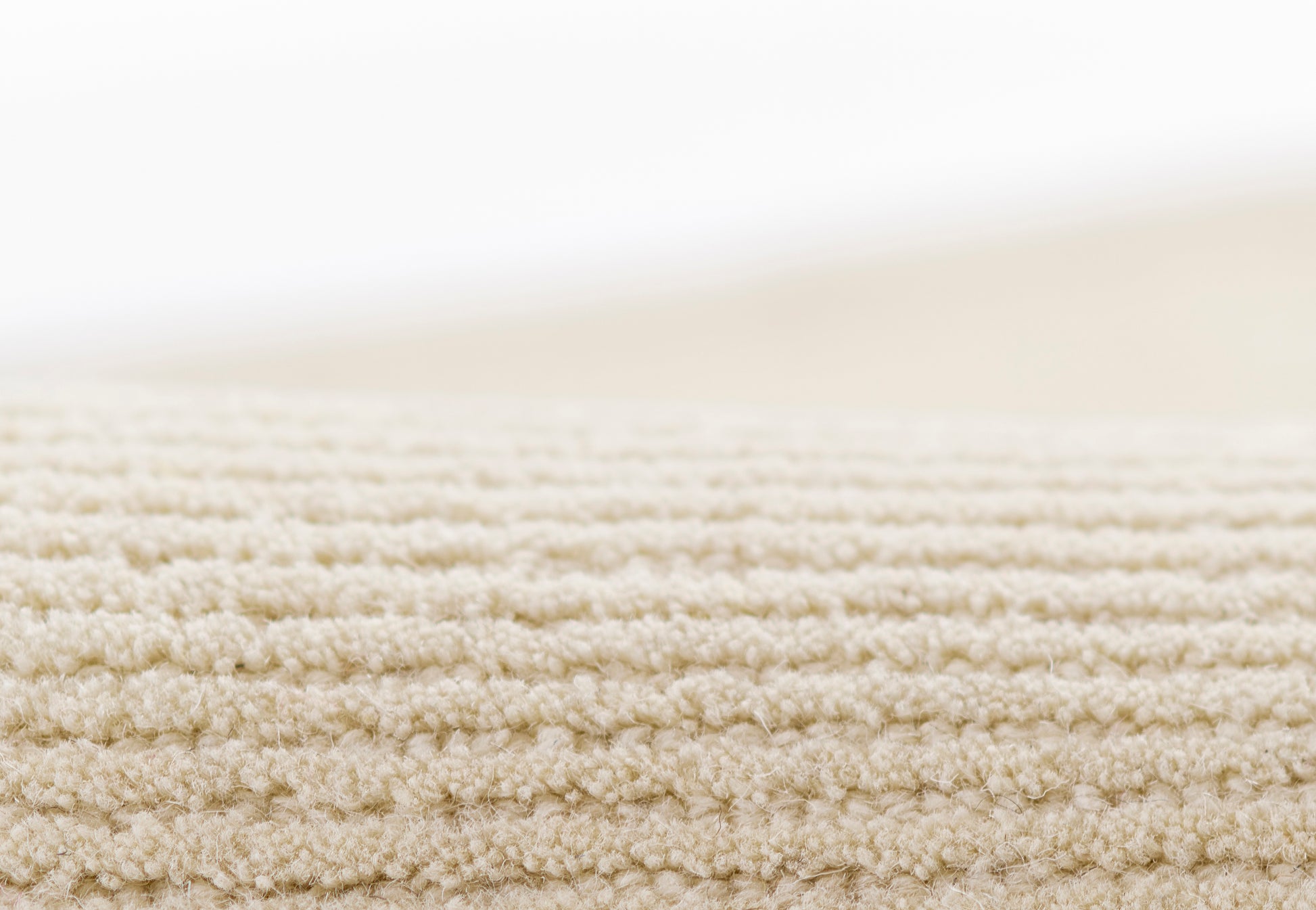 Beige textured rug with a soft loop-pile; neutral, cozy floor covering, 2' x 4'.