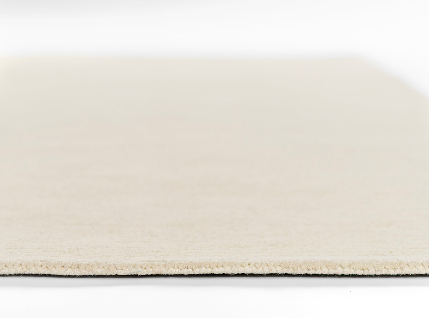 Beige rug runner swatch close-up showing textured woven fibers and flat rectangular edge.