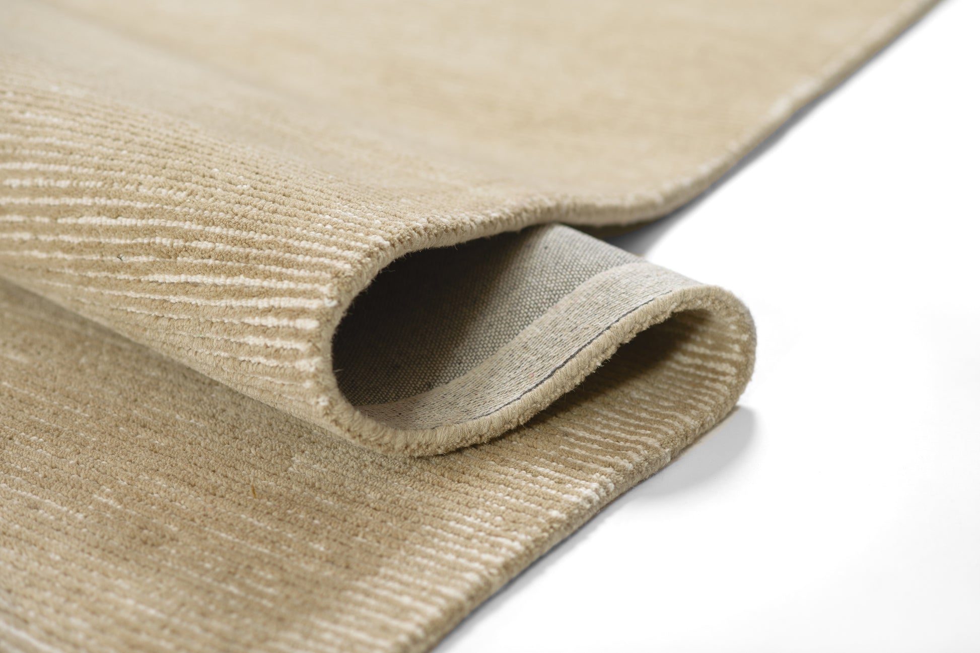 Taupe textured rug with ribbed pile and folded edge for cozy neutral decor.