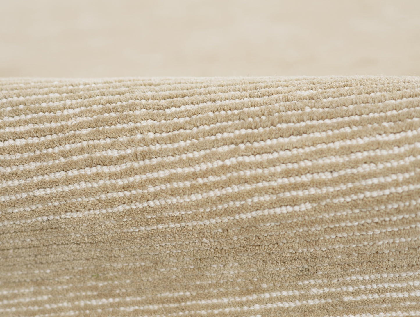 Beige taupe rug close-up showing soft loop pile with subtle cream/white horizontal stripes