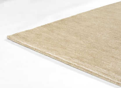 Taupe natural fiber rug with textured woven surface, rectangular flatweave, corner view.