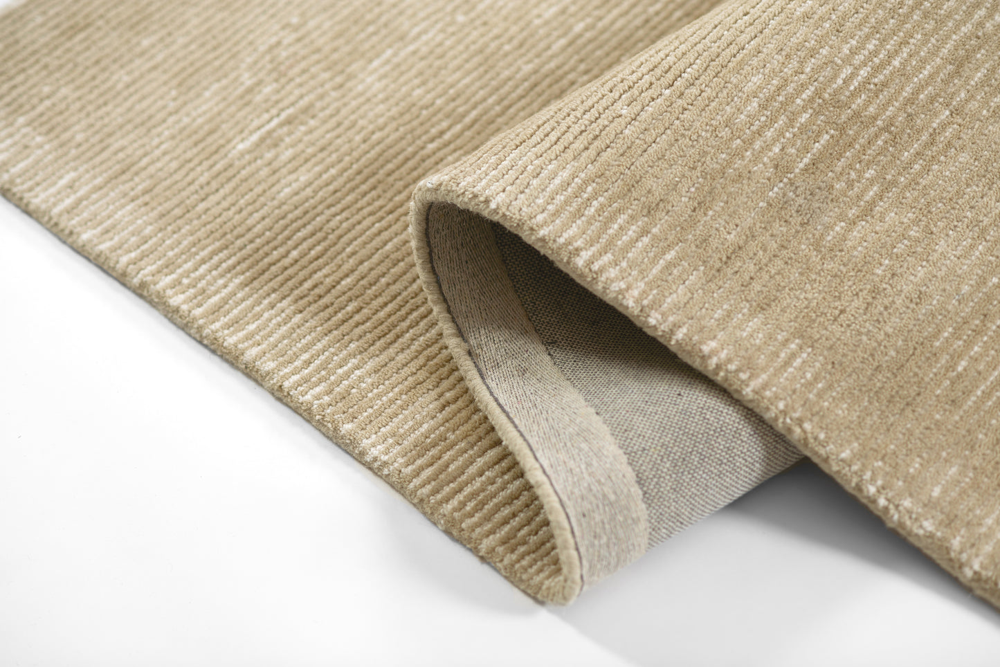 Taupe corduroy-style rug close-up with ribbed pile and folded edge showing soft backing.
