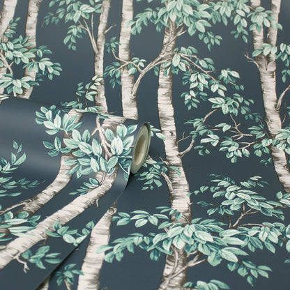 Wallpaper roll featuring blue trees on a dark teal background, partly unrolled.
