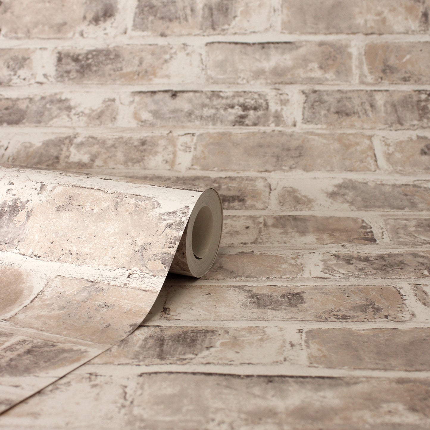 Beige distressed brick-pattern wallpaper roll with taupe/gray tones for indoor walls.