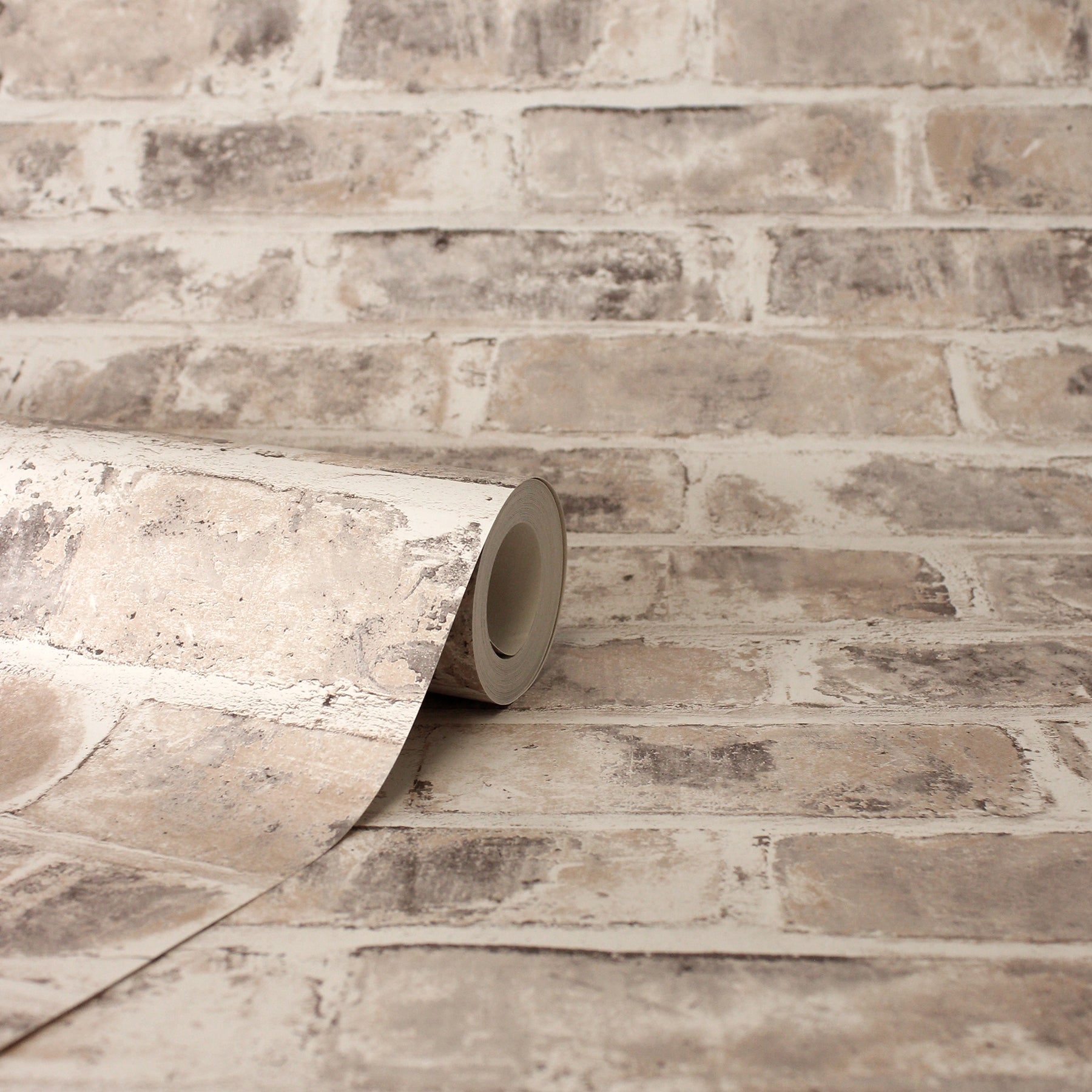 Beige distressed brick-pattern wallpaper roll with taupe/gray tones for indoor walls.