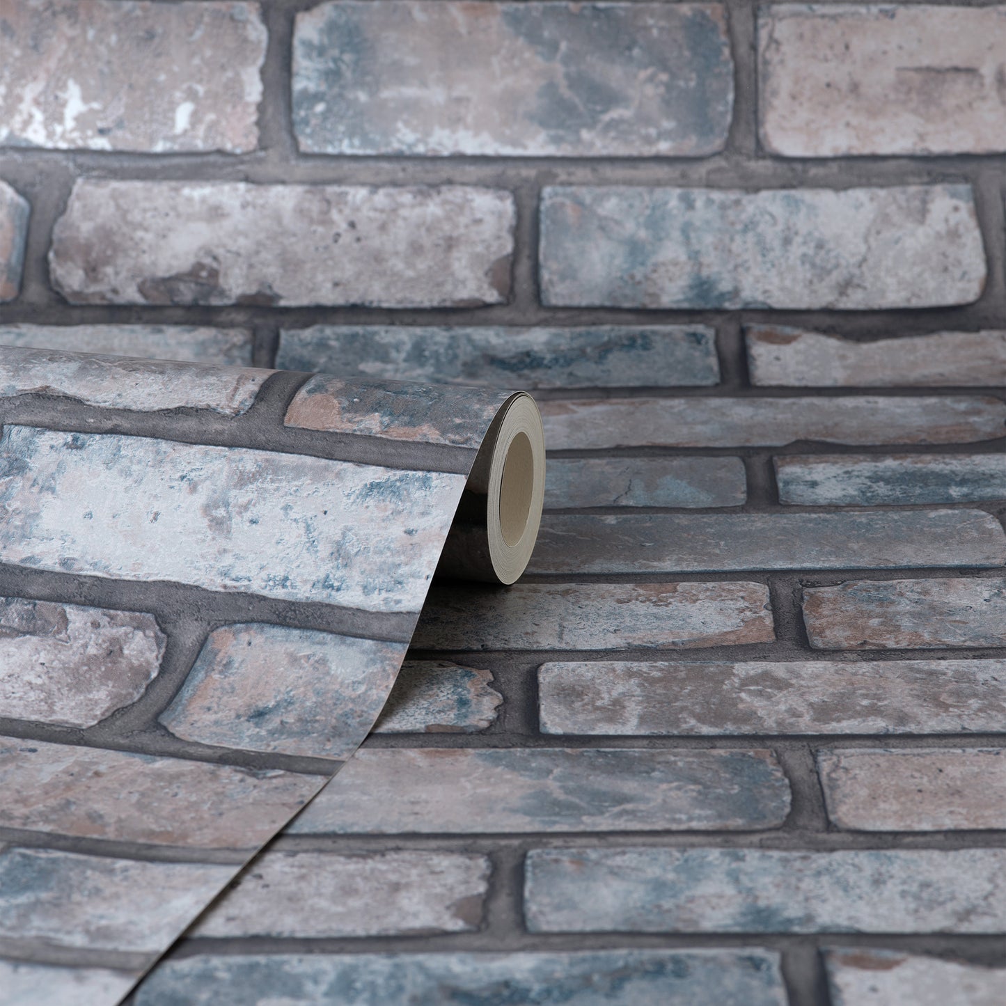 Roll of brick-pattern wallpaper in cool gray-blue tones, close-up view of textured masonry pattern.