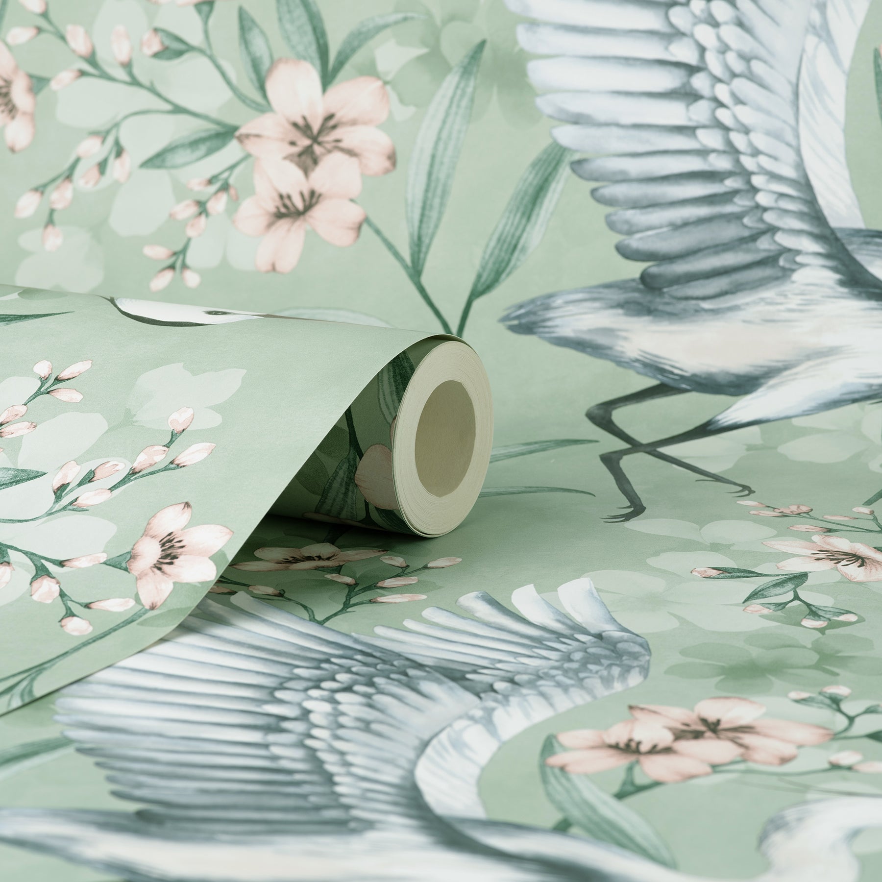 Mint green wallpaper with pink blossoms and graceful herons, rolled edge in floral botanical print.