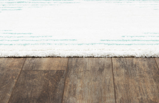 Pale blue patterned rug with a white shag fringe on a dark wooden floor.