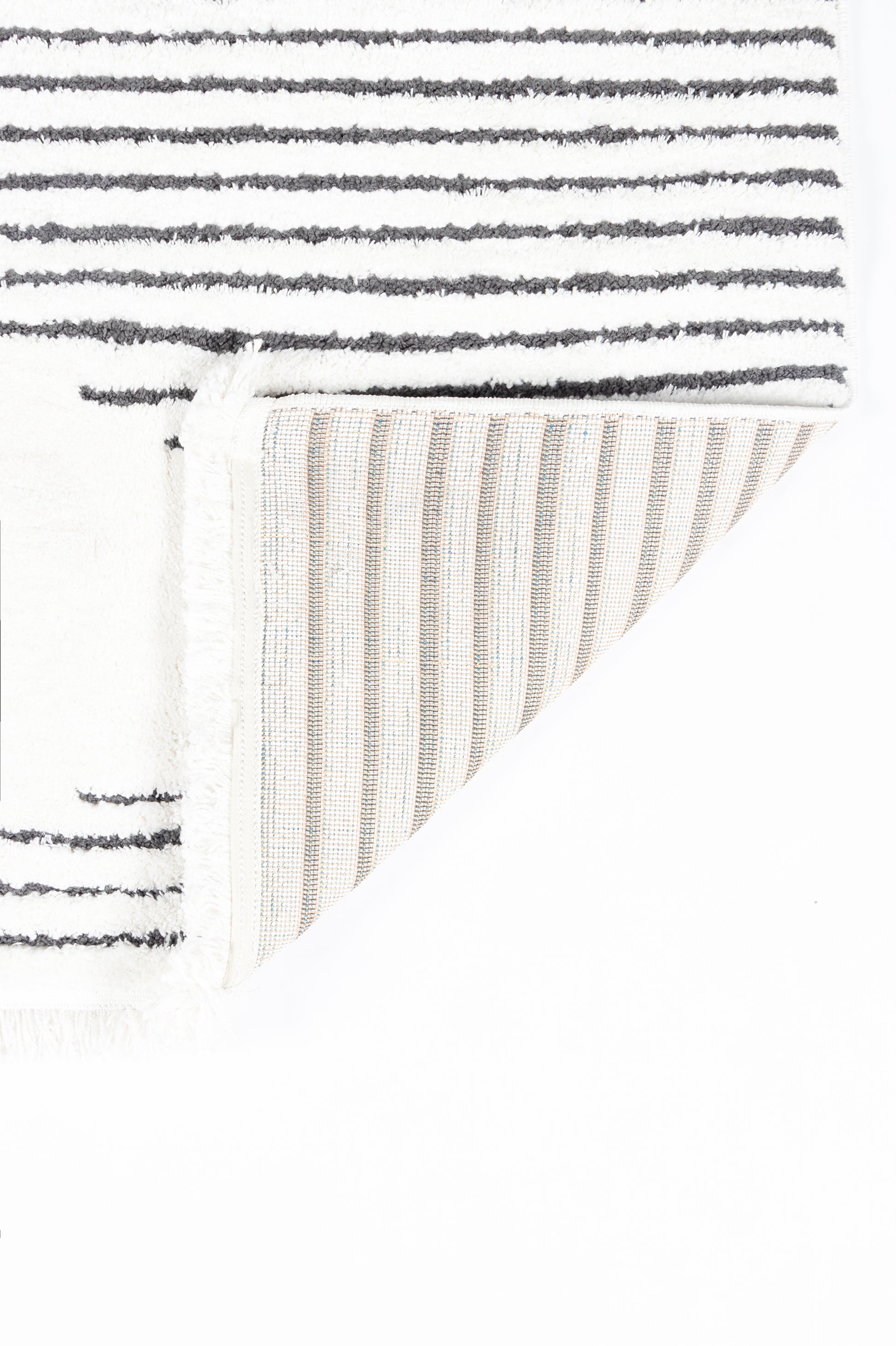 Soft white shag rug with dark gray horizontal stripes; folded corner shows cream ribbed underside.