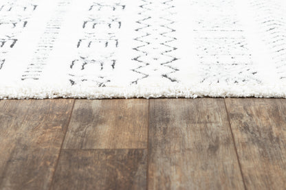 White shag rug with black geometric patterns on a dark brown wooden floor