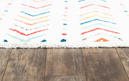 White shag rug with multicolor chevron pattern in red, blue, teal and orange on a wood floor.
