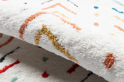 Close-up of a white plush runner rug with multicolored geometric lines in orange, gold, turquoise and red, 2' x 8'.