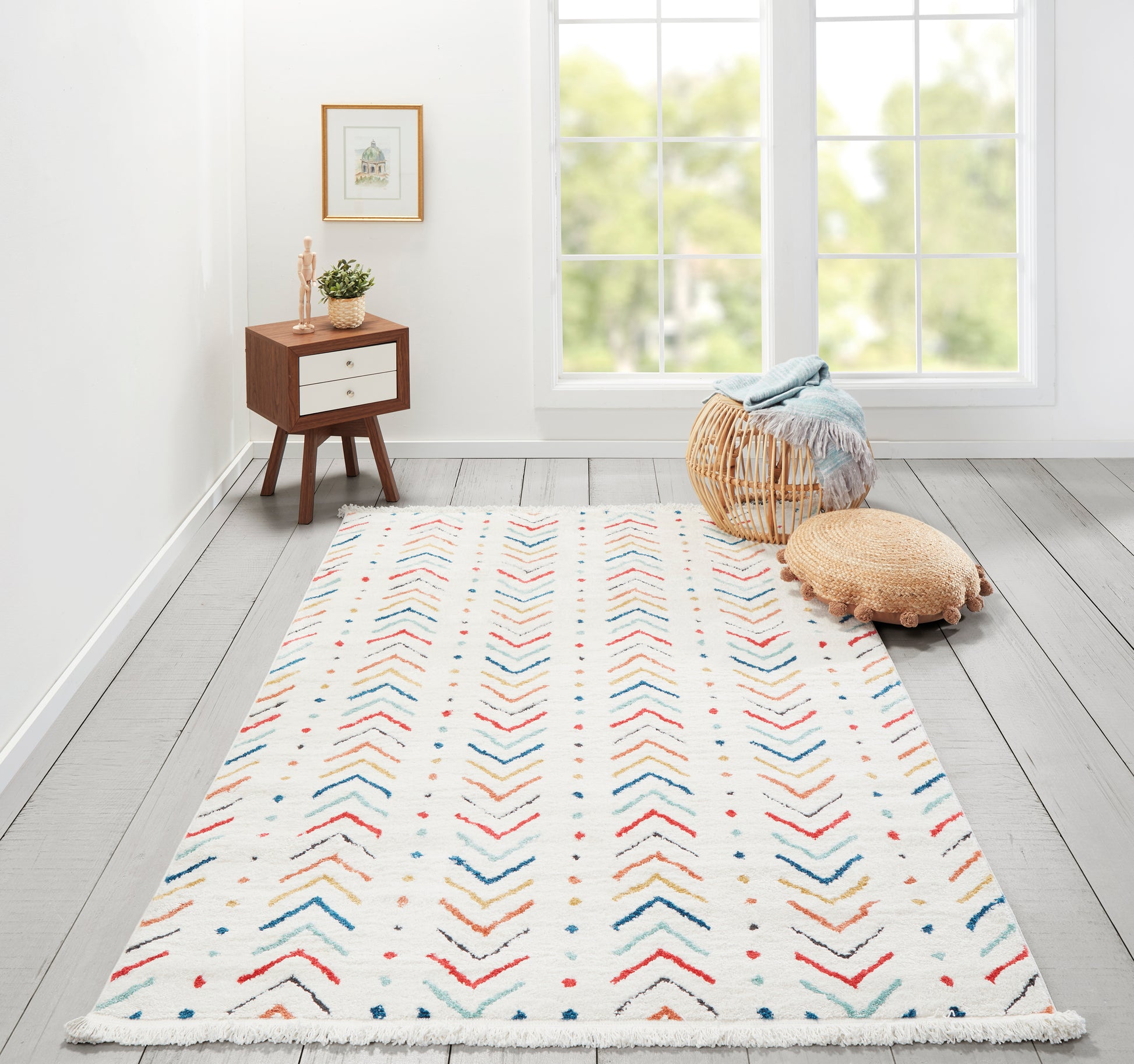 White woven runner rug with multicolor chevron pattern and fringed edges; mid-century wooden side table, wicker pouf, sunlit room.