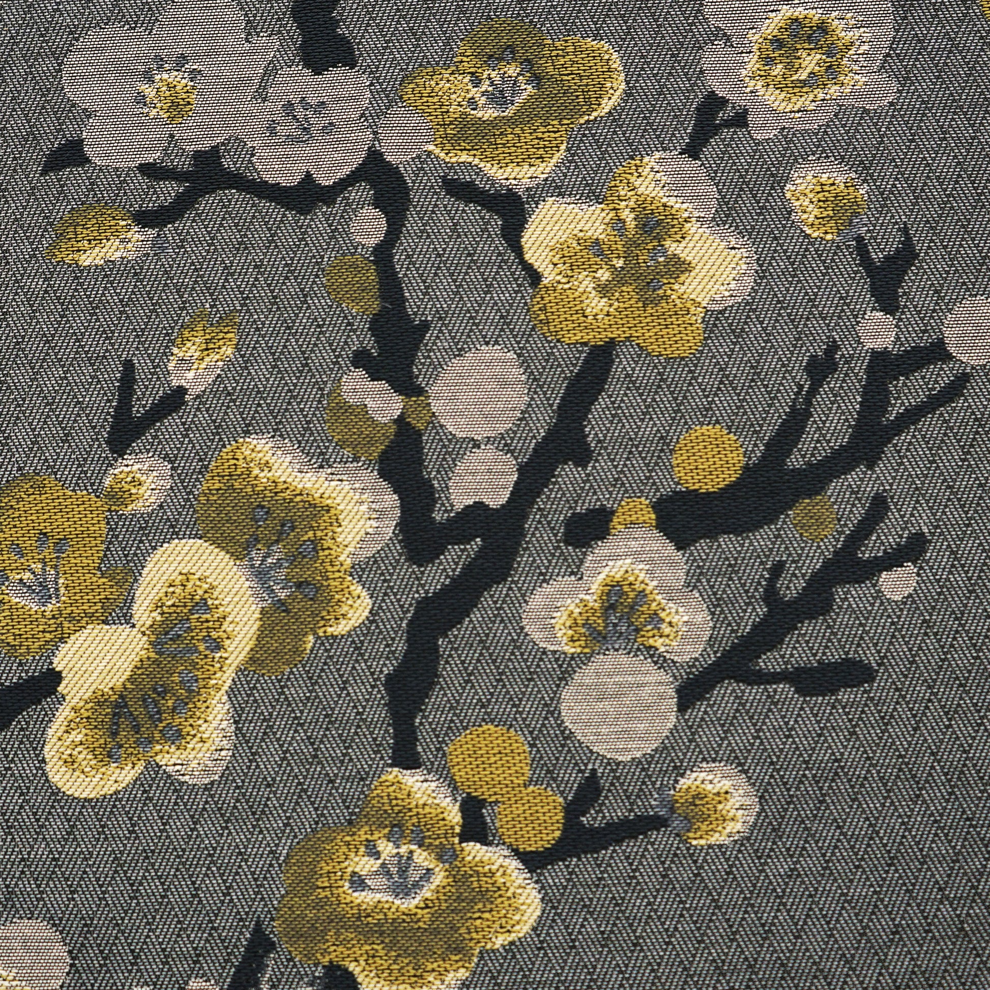 Grey woven fabric with dark branches and yellow ivory plum blossoms on a subtle herringbone background