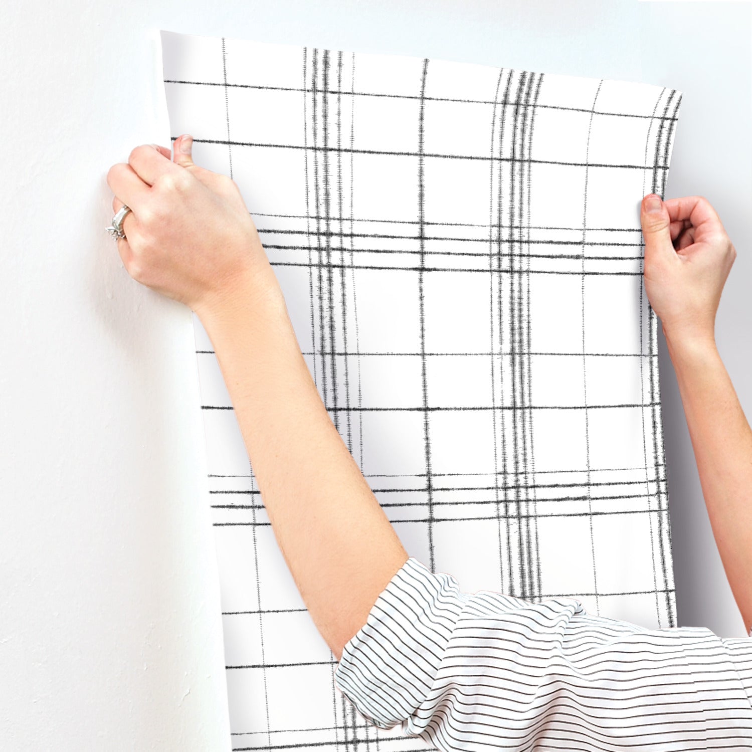 Close-up of beige and neutral farmhouse plaid wallpaper with a black and white grid pattern.