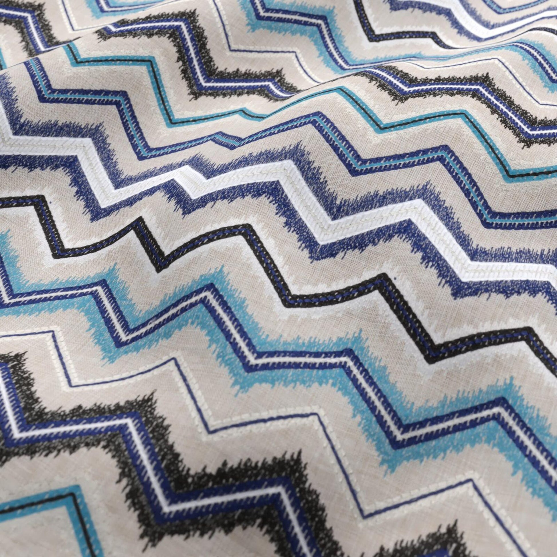 Chevron zigzag fabric in blue, teal, black, and white with textured woven stripes.