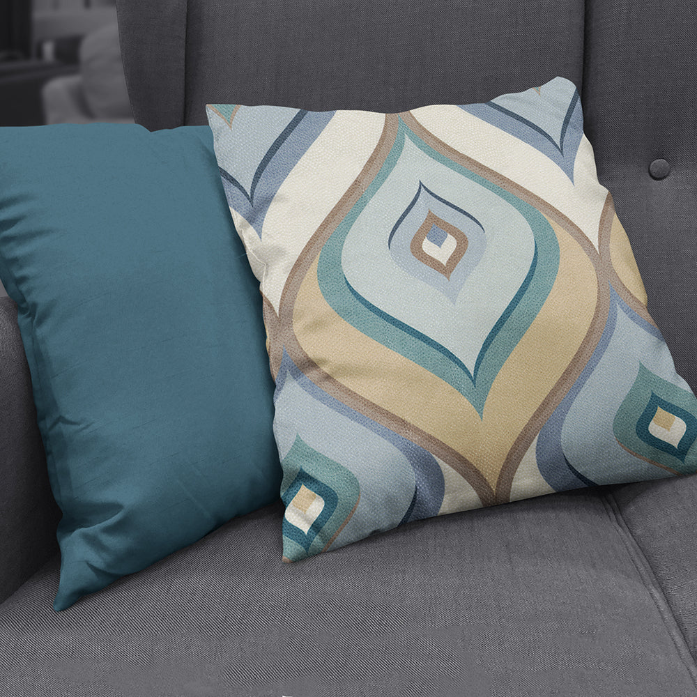 Teal solid throw pillow on a dark gray sofa.