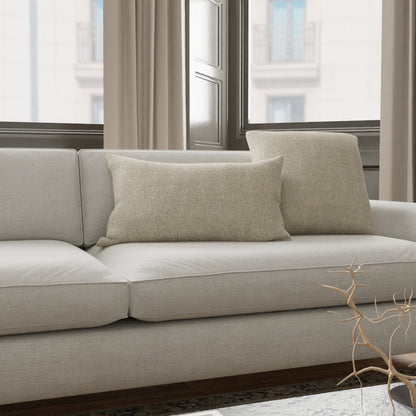 Tan textured fabric upholstery in a modern living room setting; soft natural light from a window and minimalist decor.