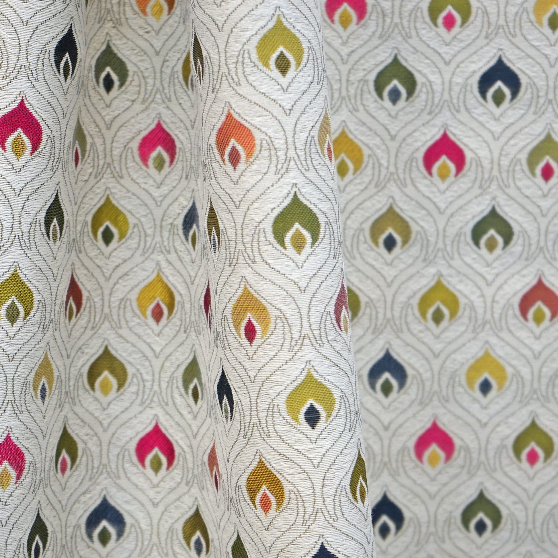 Green jacquard fabric with multicolor flame-teardrop motifs in pink, yellow, orange, green, and blue, outlined with silver threads.