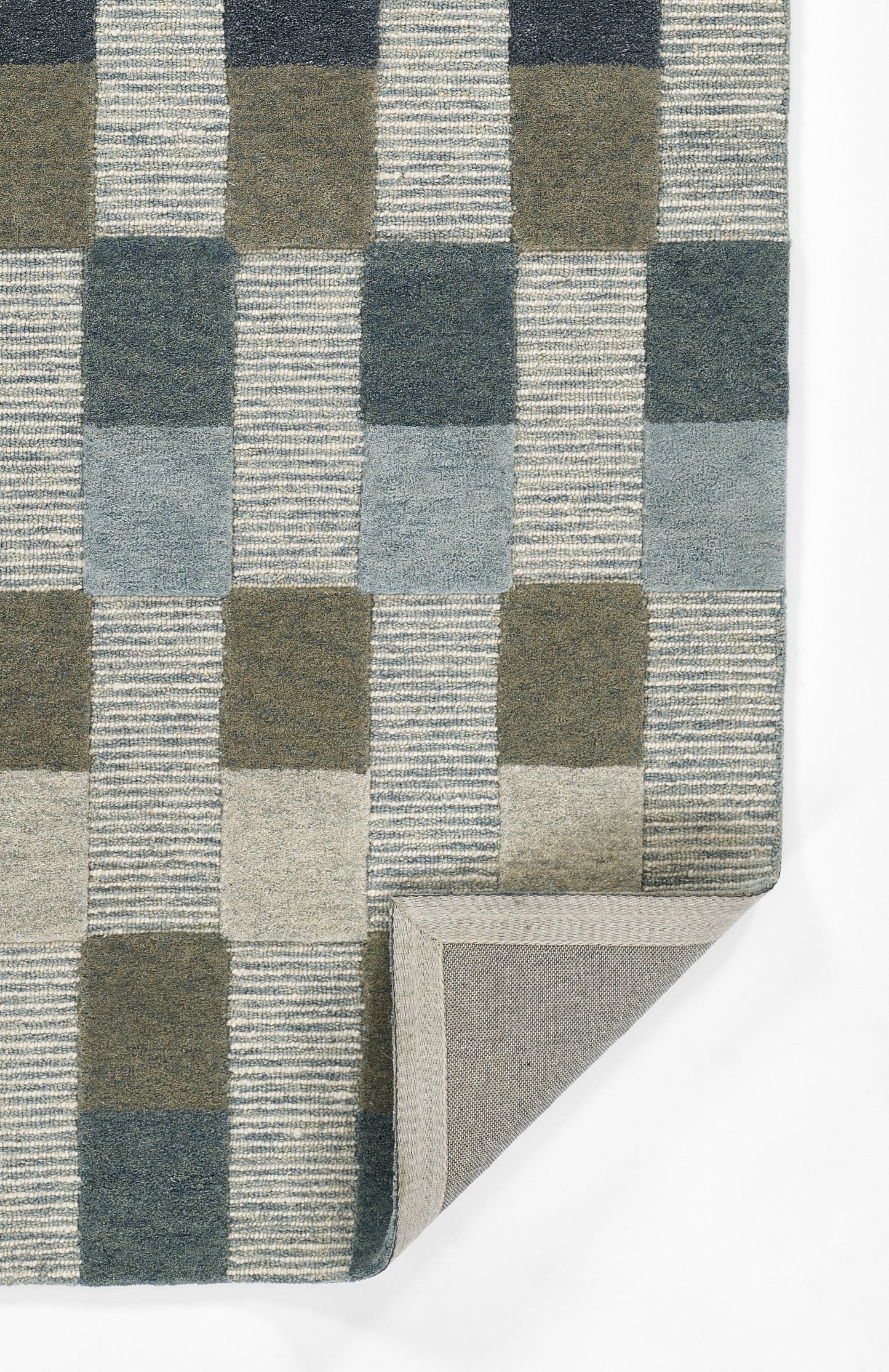 Geometric checkered rug in blue, gray, and olive tones; woven flat-weave with striped square blocks, folded corner.