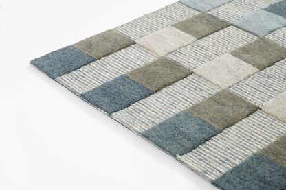 Geometric area rug with blue, gray, olive and beige square blocks; modern low-pile design.